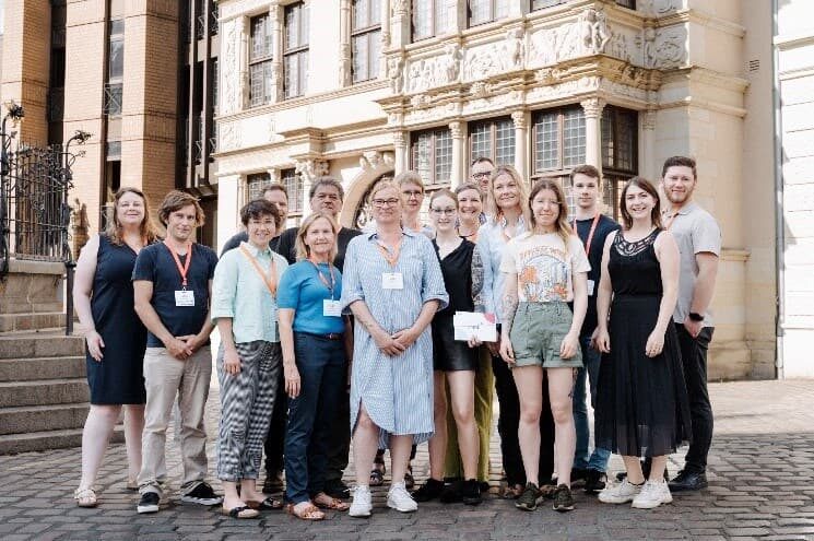 Gruppenfoto des twillo-Teams und weiterer Beteiligter vor einem historischen Gebäude bei der Veranstaltung 'Open Up – Wie können wir die Digitalisierung für offene Bildung nutzen?'